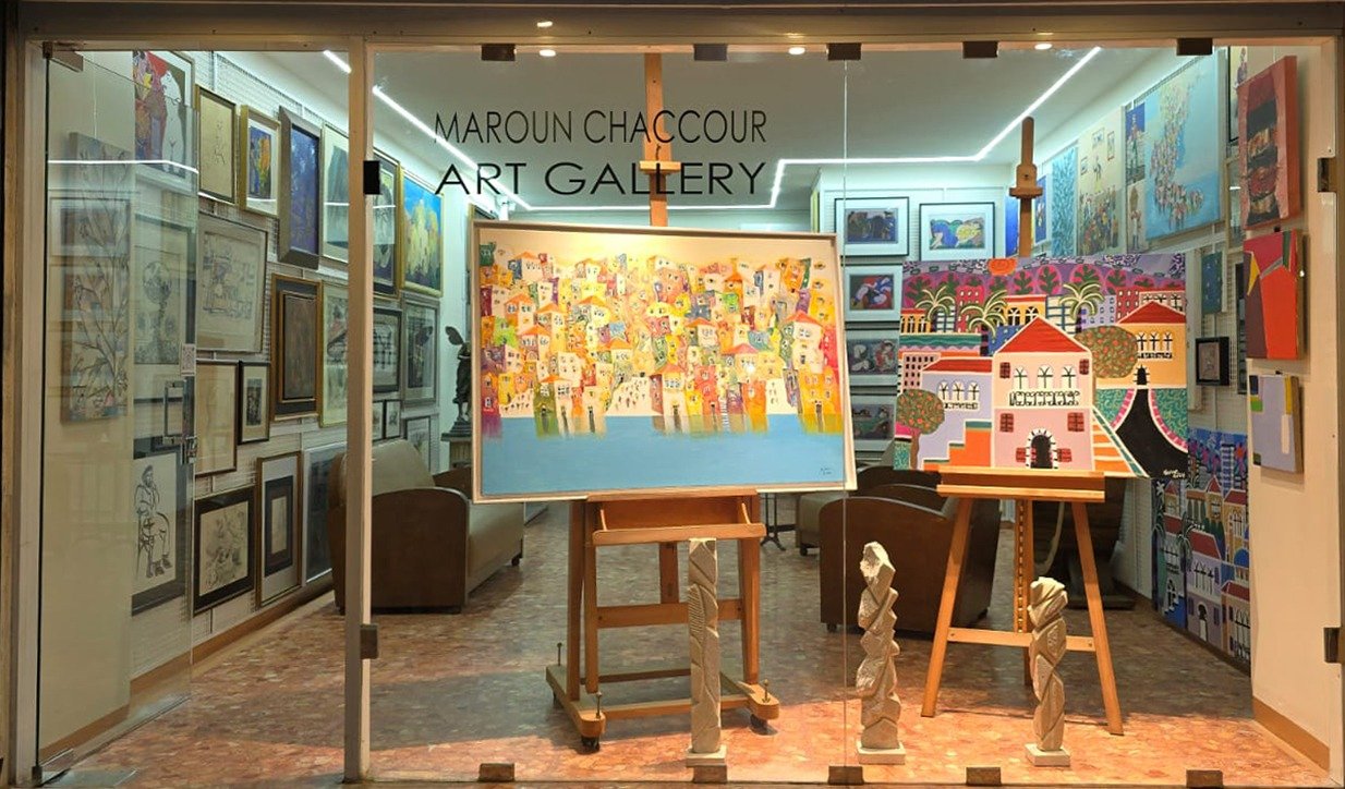 Storefront of the Maroun Chaccour Art Gallery in Beirut, paintings on easels in the window